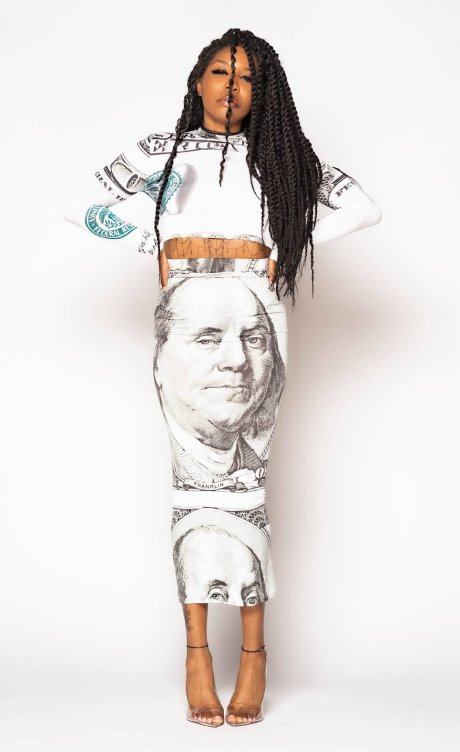 Founder standing with arms on hips in a black and white dress